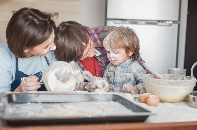 family covered in flour while baking