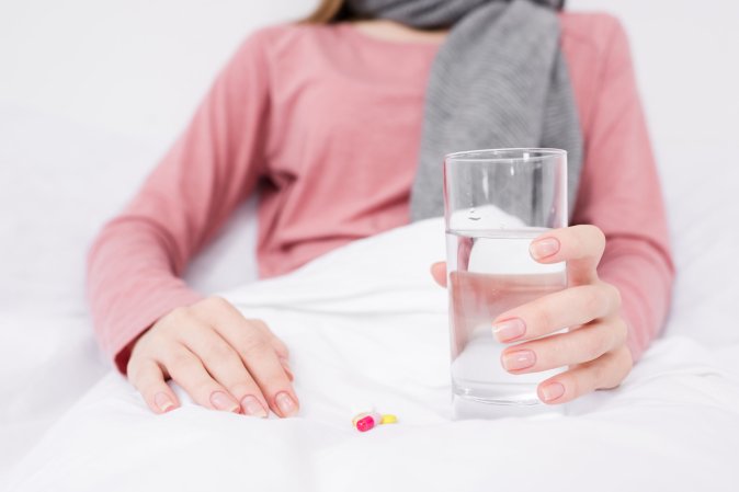 woman in bed with pills