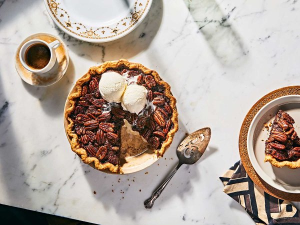 Bourbon Chocolate Pecan Pie served with vanilla ice cream on marble counter.