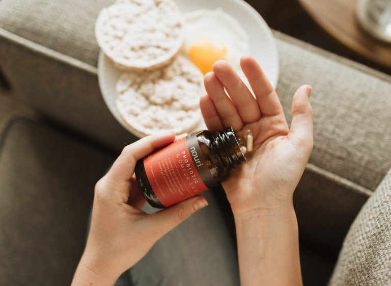 probiotic bottle being tipped into someone's hand