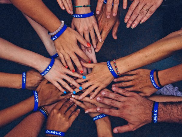 a bunch of people putting their hands together