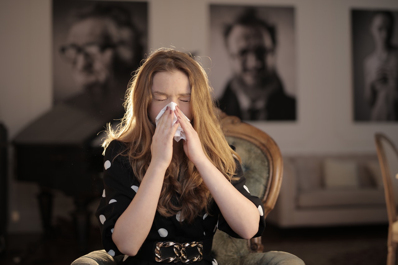 Woman with tissue sneezing