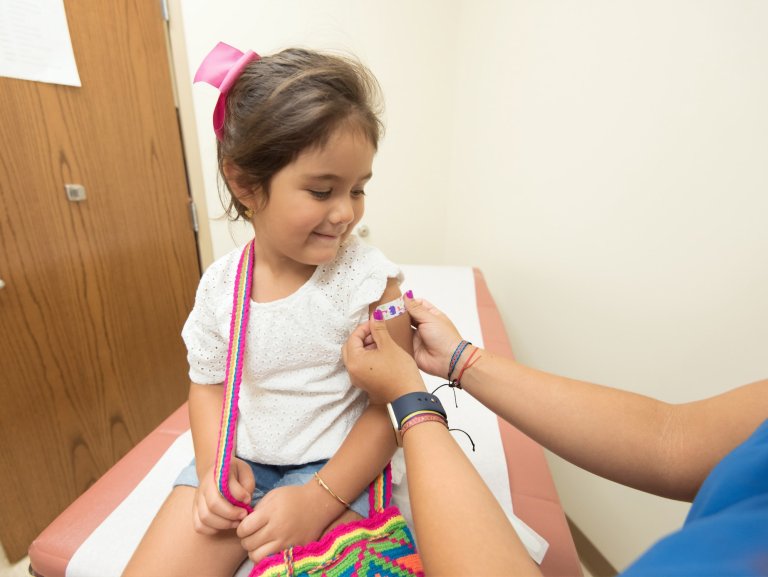 child getting bandage after a vaccine