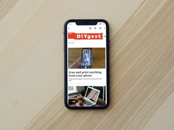 iPhone on a wooden table with a newsletter on the screen
