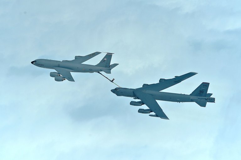 A bomber is refueled behind a tanker airplane.