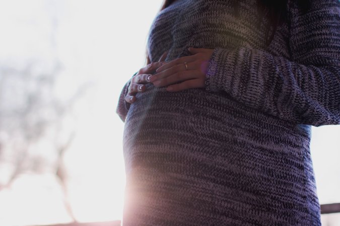 a pregnant person touches their belly