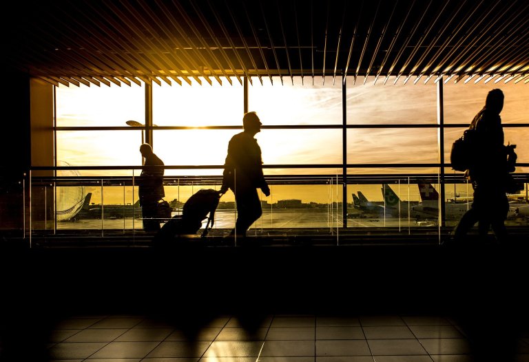 Person with luggage traveling through airport during COVID-19 pandemic