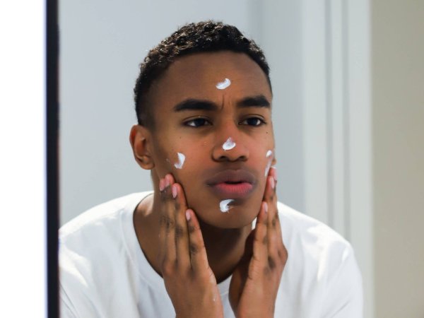 person-looking-at-mirror-applying-face-cream