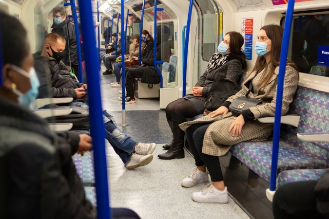 Passengers on a train wear face masks.