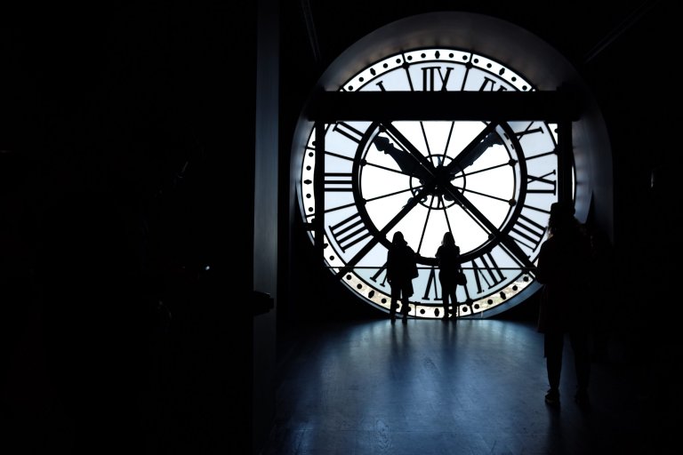 people walking in front of clock