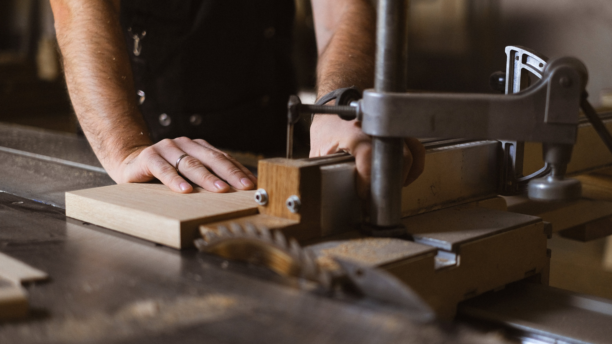 A person using a crosscut sled on a table saw.