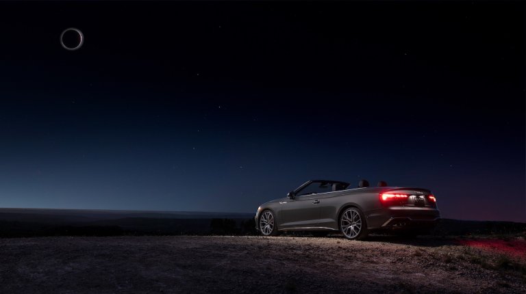 a convertible in blackness during the eclipse