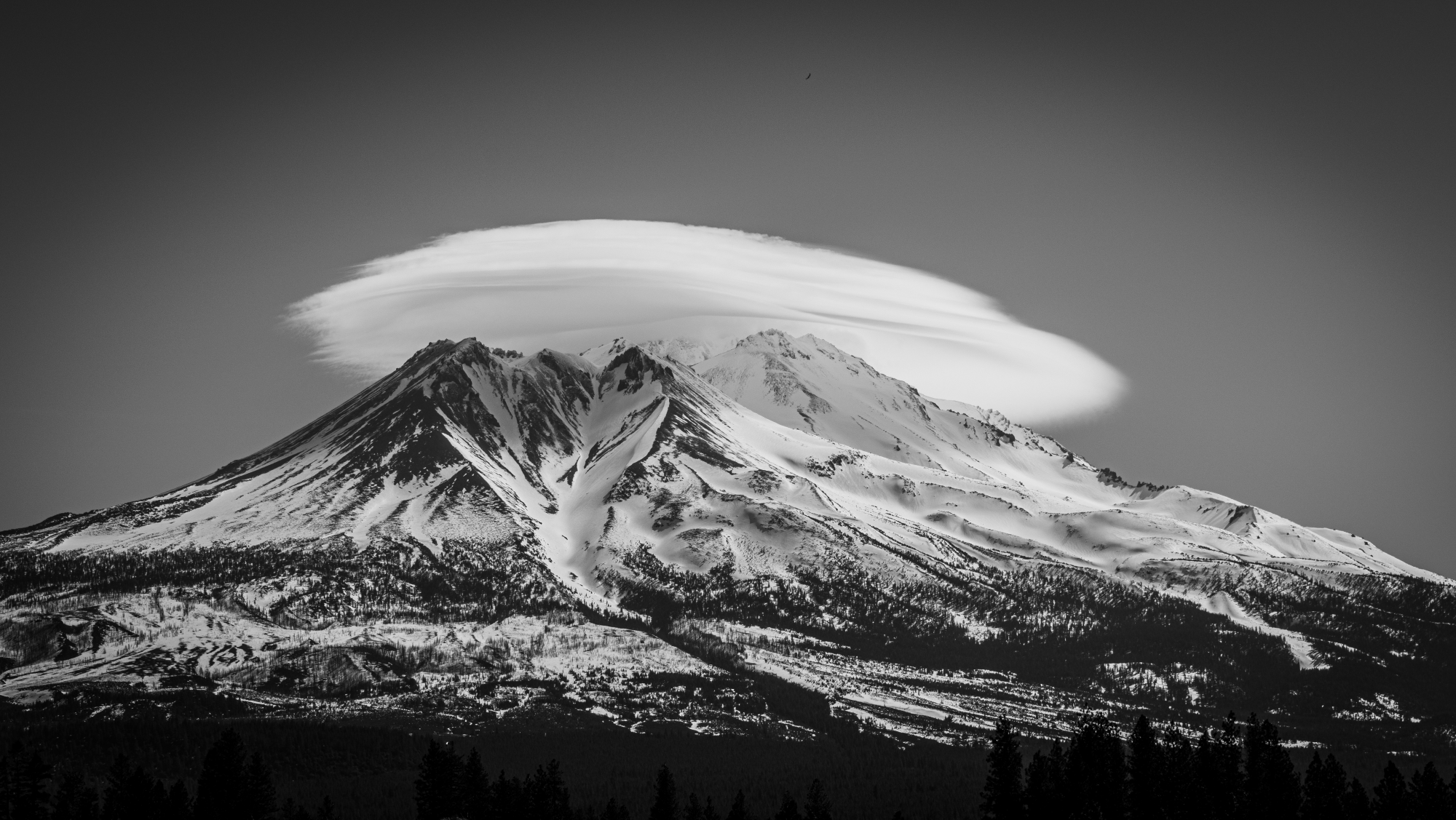 a large circular cloud covers the top of a mountain