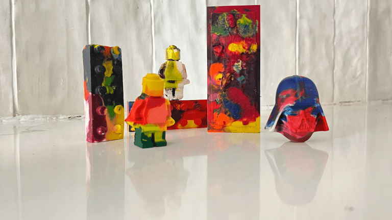 rainbow crayons of darth vader, han solo, and lego minifigs on a countertop