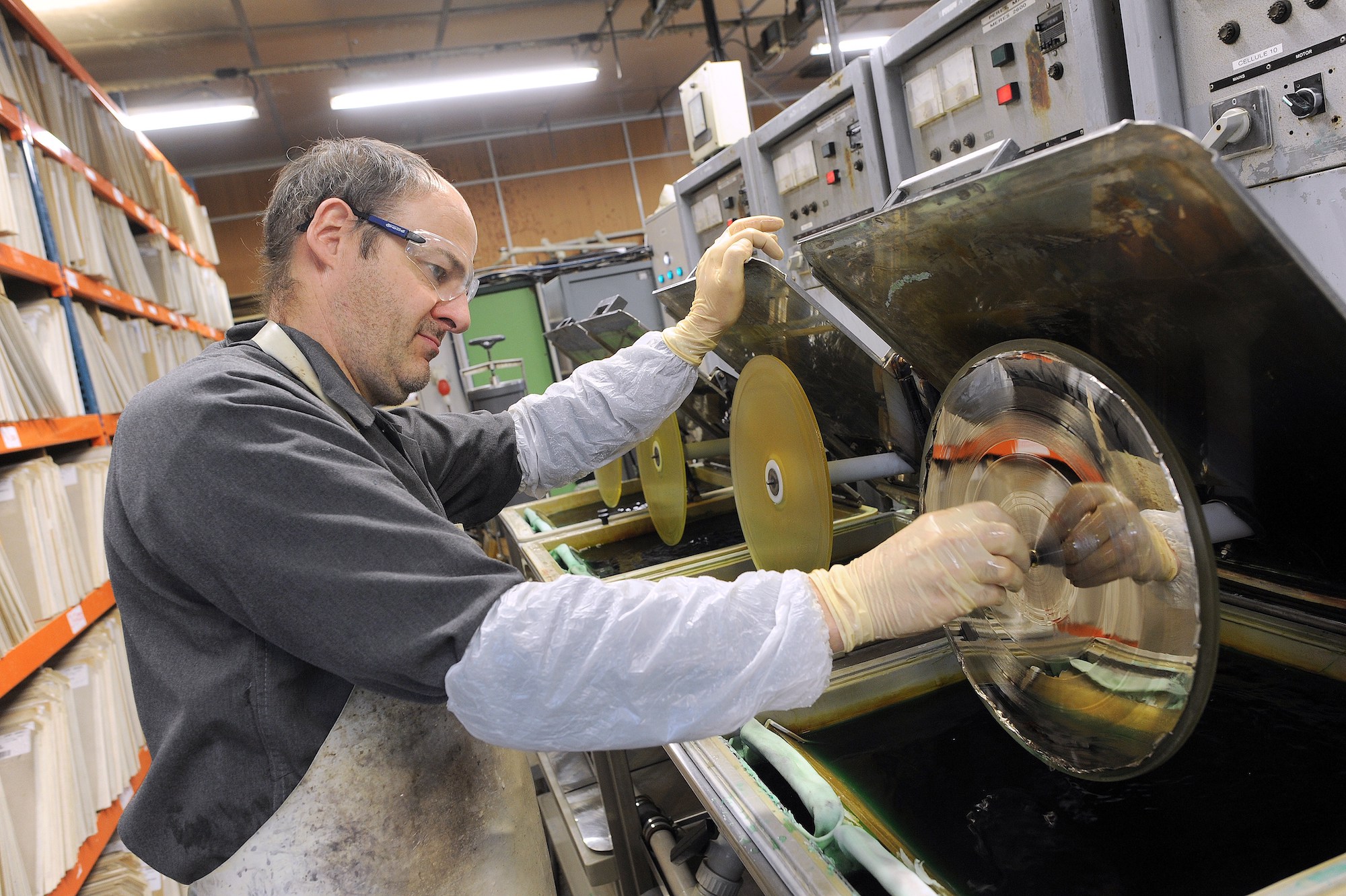 A worker puts the master in a tank on a production line at the MPO International company, the last French manufacturer in Averton, western France, on March 7, 2014. The vinyl recording, promised to the museum, competes again with digital supports. 