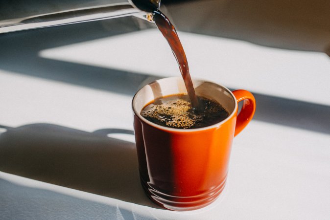 coffee pot pouring coffee into a mug